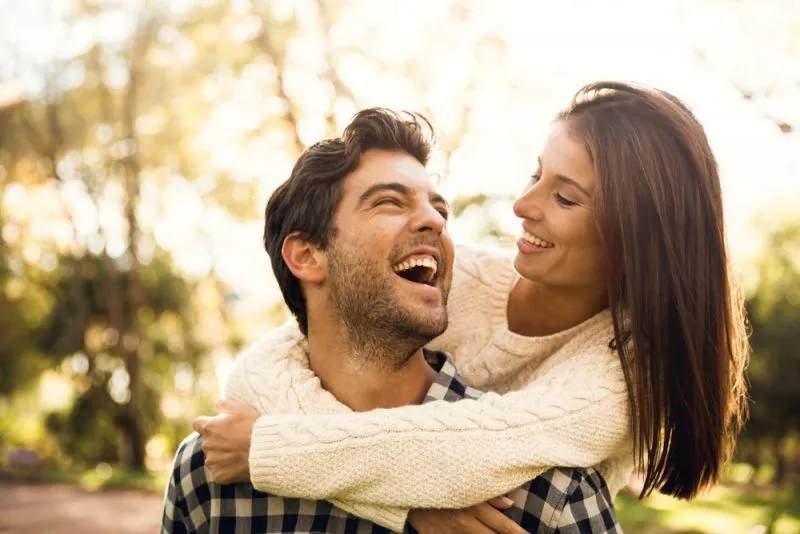 happy couple outside embracing and smiling at each other